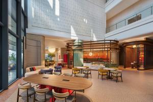 a lobby of a hotel with tables and chairs at voco Kuching by IHG in Kuching
