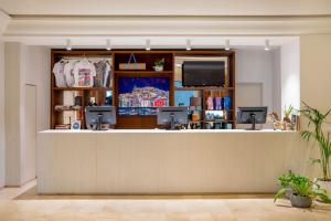 a store counter with a flat screen tv at INNSiDE by Meliá Ibiza Beach in San Antonio Bay