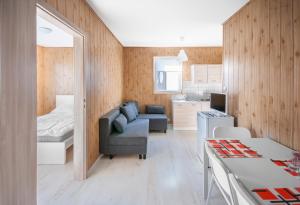 een woonkamer met een bank en een bed en een keuken bij Cuma Camp in Sarbinowo