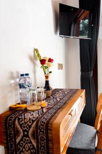a table with a vase of flowers on top of it at Uma Harum Sari by Dhananjaya Hospitality in Penginyahan