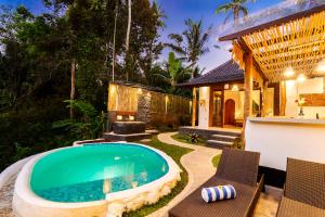 a swimming pool in the backyard of a house at Uma Harum Sari by Dhananjaya Hospitality in Penginyahan