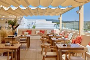 a restaurant with tables and chairs on a balcony at ME by Meliá Ibiza - The Leading Hotels of the World in Santa Eularia des Riu
