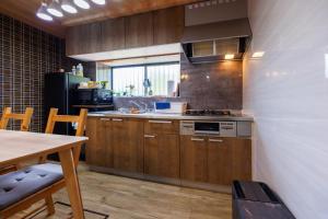 a kitchen with wooden cabinets and a table and a stove at ネバーランド伊豆 Neverland IZU in Ito
