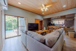 a living room with a large couch and a kitchen at ネバーランド伊豆 Neverland IZU in Ito