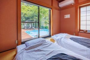 a room with two beds and a window with a swimming pool at ネバーランド伊豆 Neverland IZU in Ito +48 photos
