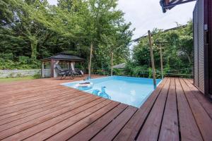 a deck with a pool and a gazebo at ネバーランド伊豆 Neverland IZU in Ito