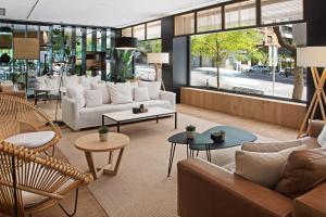 a lobby with couches and tables in a store at Meliá Madrid Serrano in Madrid