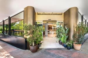 a lobby of a mall with potted plants at Meliá Madrid Serrano in Madrid