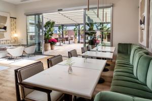 a restaurant with white tables and green chairs at Meliá Madrid Serrano in Madrid +112 photos