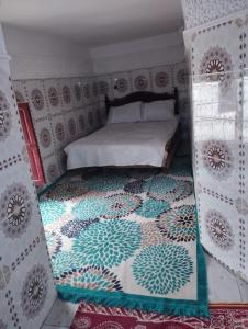 a bedroom with a bed with a patterned wall at Ryad Cherkaoui in Fez