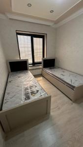 two twin beds in a room with a window at Квартира in Samarkand