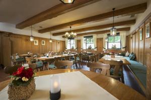 un restaurante con mesas de madera, sillas y velas en Gasthaus Glaser, en Bad Füssing