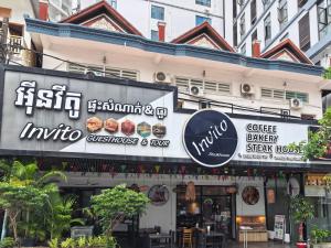 a restaurant with signs on the side of a building at Invito Guesthouse in Sihanoukville