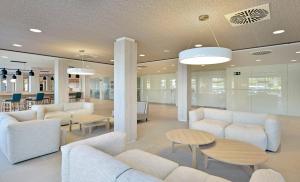 a lobby with white couches and tables and chairs at SOL by Meliá Marbella Estepona - Atalaya Park in Estepona