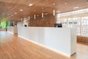 an office lobby with a white reception desk and windows at SOL by Meliá Marbella Estepona - Atalaya Park in Estepona +94 photos