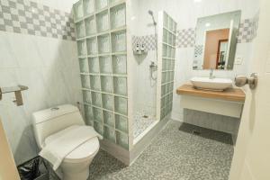 a bathroom with a toilet and a sink at Alona Garden Suites in Panglao Island +19 photos
