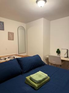 a bedroom with a bed with blue sheets and a desk at The atlas - Shared apartment in New York
