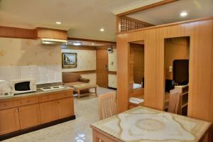 a kitchen and a living room with a microwave at The Kaze 34 Hotel and Serviced Residence in Bangkok
