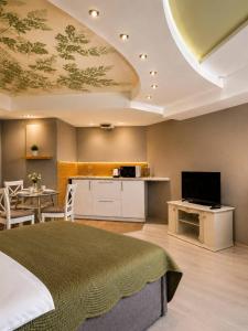 a bedroom with a bed and a kitchen with a tv at Апартаменти Мост Сіті in Dnipro +5 photos