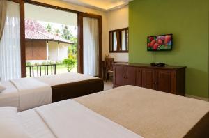 a hotel room with two beds and a window at mascot hotel senggigi in Senggigi