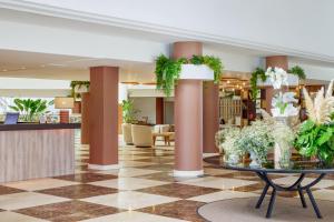a lobby with columns and a table with plants at Meliá La Palma in Puerto Naos