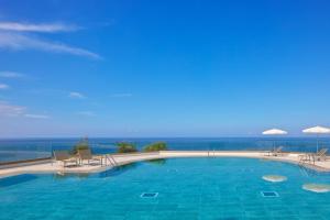 a large swimming pool with chairs and umbrellas at Meliá La Palma in Puerto Naos +84 photos