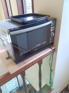 a microwave sitting on top of a table at YCS2 Guest house, good access to Shinjuku in Nishitokyo