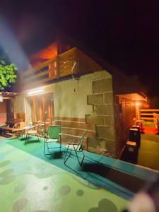 a house with chairs and a swimming pool at night at Lesní chata Hvězdička in Litoměřice