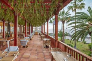 a restaurant with tables and chairs and the ocean at Apartments La Palma, Affiliated by Meliá in Puerto Naos