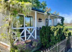 a cottage with a white fence and purple flowers at Willowtree Cottage Gated Country Luxury Near Lincoln Uni & Wedding Venues in Lincoln +31 photos