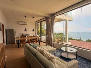 a living room with a couch and a large window at v15 Ocean Serenity Residence in Ko Phangan