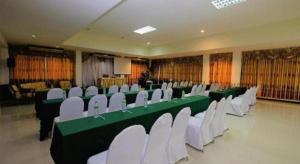 a banquet hall with green and white tables and chairs at PC Palace Hotel in Sakon Nakhon