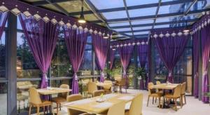 a restaurant with purple curtains and tables and chairs at Nanning Champs Elysees Hotel in Nanning