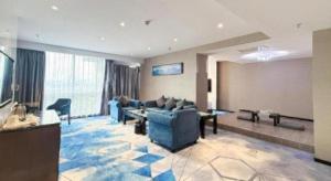 a large living room with blue couches and a television at Nanning Champs Elysees Hotel in Nanning