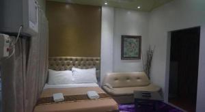 a small bedroom with a bed and a couch at Zanrock Micro Hotel in Lagao III