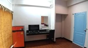 a room with a desk with a television and a mirror at Tantawan Place in Roi Et