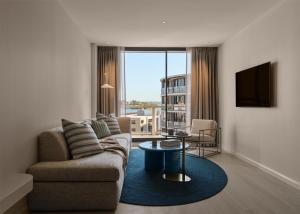 a living room with a couch and a table at Adina Sydney Darling Harbour in Sydney