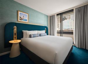 a bedroom with a large white bed and a window at Adina Sydney Darling Harbour in Sydney +50 photos