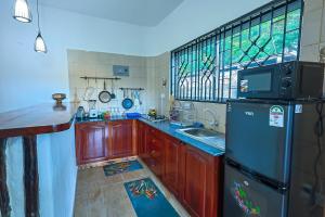 a kitchen with a refrigerator and a sink and a window at Janari Stays in Kilifi