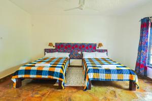 two beds sitting next to each other in a room at Janari Stays in Kilifi +4 photos