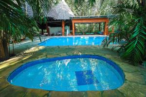 a swimming pool with blue water in a resort at Janari Stays in Kilifi