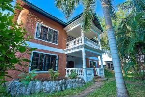 a house with a palm tree in front of it at Janari Stays in Kilifi