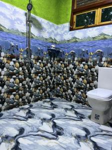 a bathroom with a stone wall and a toilet at NETHSARA cottage in Ella +42 photos