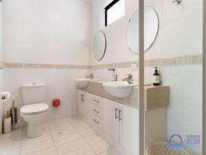 a white bathroom with two sinks and a toilet at Summer Breeze at Avalon Beach in Wannanup +24 photos