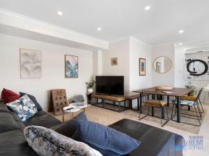 a living room with a couch and a table at Summer Breeze at Avalon Beach in Wannanup