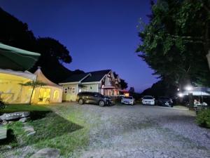 a group of cars parked in a driveway at night at Hwacheon Sankkun-uijib Pension in Hwach'ŏn