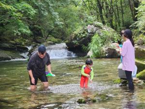 a group of people in the water in a creek at Hwacheon Sankkun-uijib Pension in Hwach'ŏn