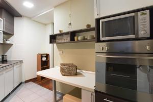 a kitchen with a table and a microwave at Apartments Zagreb Point - Vinogradska in Zagreb