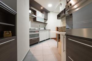 una cocina con armarios blancos y encimeras grises en Apartments Zagreb Point - Vinogradska, en Zagreb
