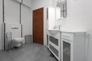 a white bathroom with a toilet and a sink at Apartments Zagreb Point - Vinogradska in Zagreb +18 photos
